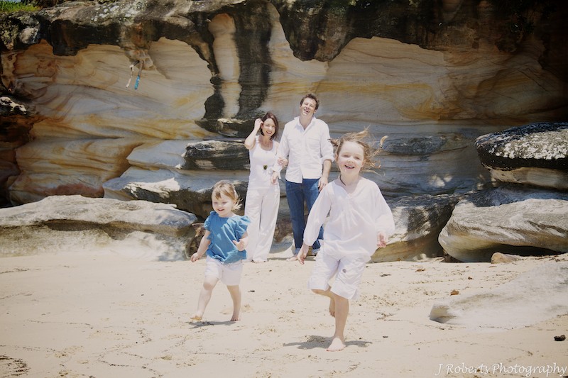 Kids having a running race on the beach - family portrait photography sydney